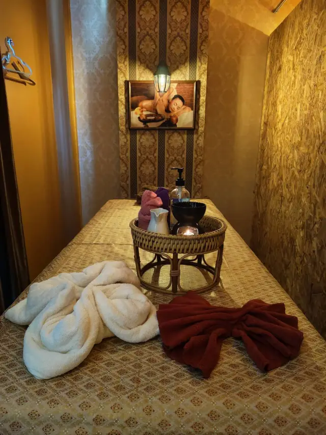 Massage bed with towels and an oil tray in a small room at Ai Oon Massage Lanna