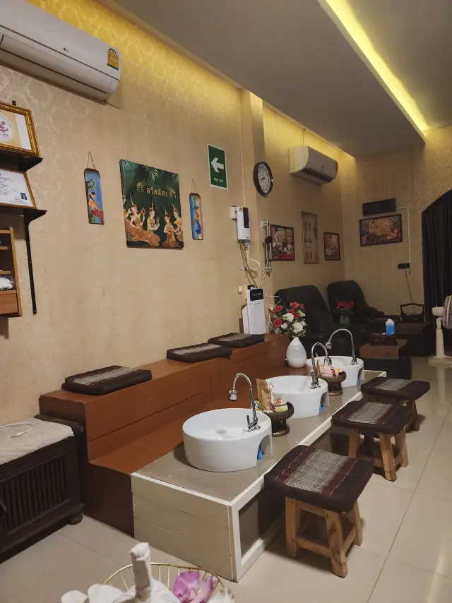 Foot-wash basins and wooden stools beside the massage mats at Ai Oon Massage Lanna