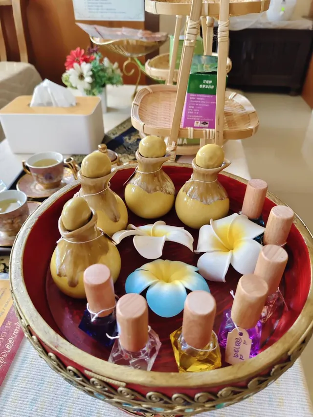 Tray of ceramic oil pots, glass oil bottles and plumeria flowers at Ai Oon Massage Lanna