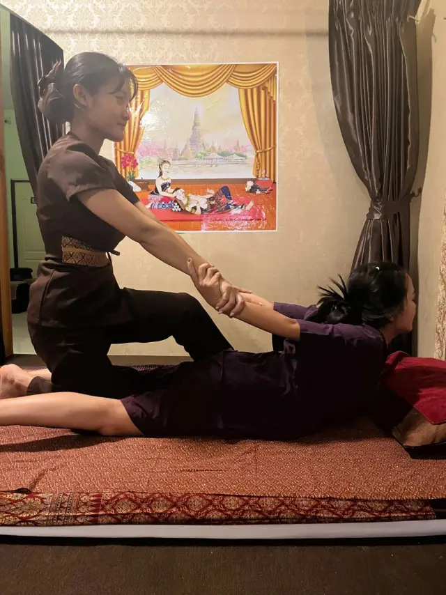 Therapist giving a Thai stretching massage to a guest on a floor mat at Ai Oon Massage Lanna