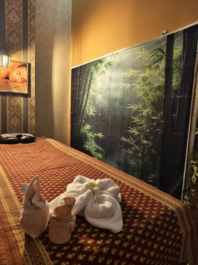 Massage bed with towel animals and a bamboo mural at Ai Oon Massage Lanna, Chiang Mai