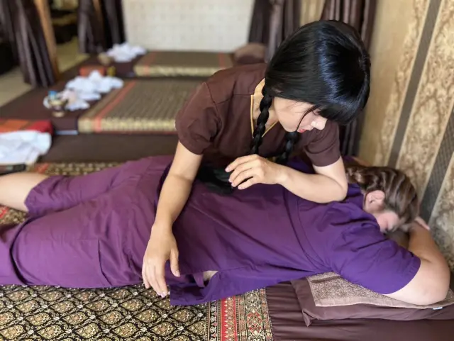 Therapist massaging a guest's back and shoulders on the floor mats at Ai Oon Massage Lanna