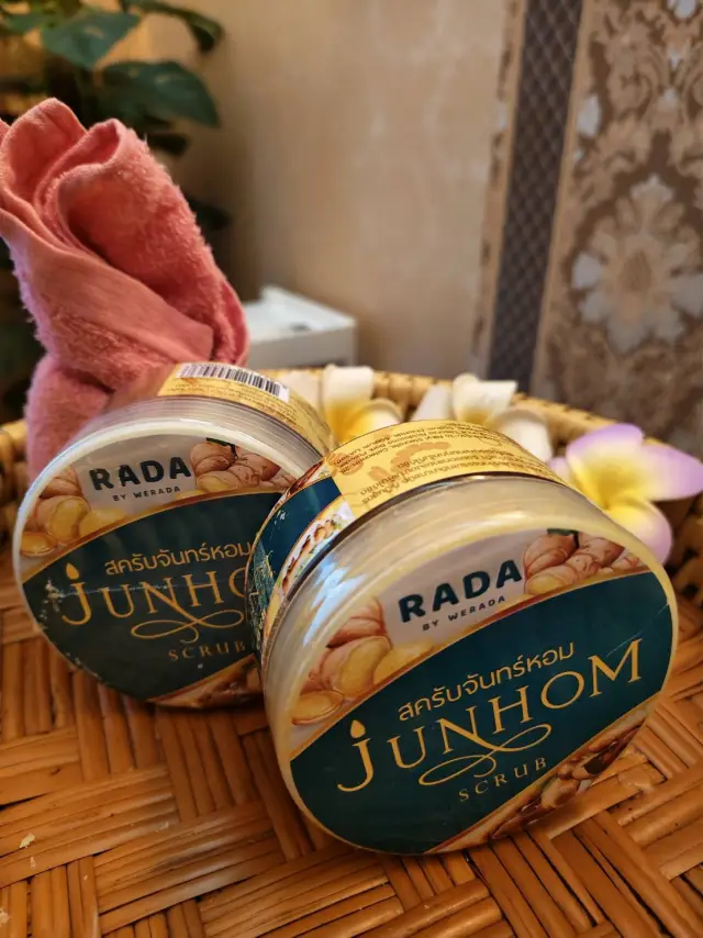 Junhom scrub jars with a pink towel and plumeria flowers on a woven mat, Chiang Mai