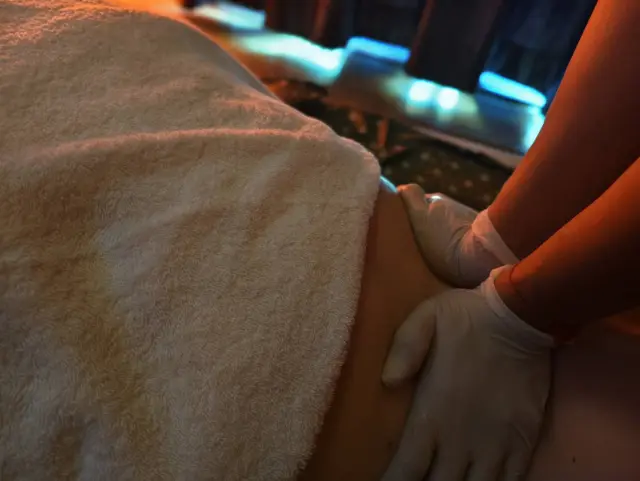 Therapist's gloved hands giving a massage to a guest covered with a towel, Chiang Mai